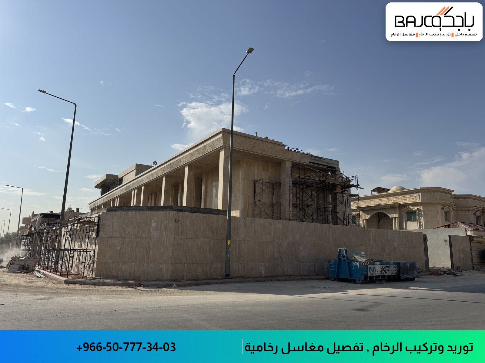 واجهة مبنى إداري بألوان فاتحة وأعمدة معمارية، محاط بسياج معادني وأدوات إنشائية