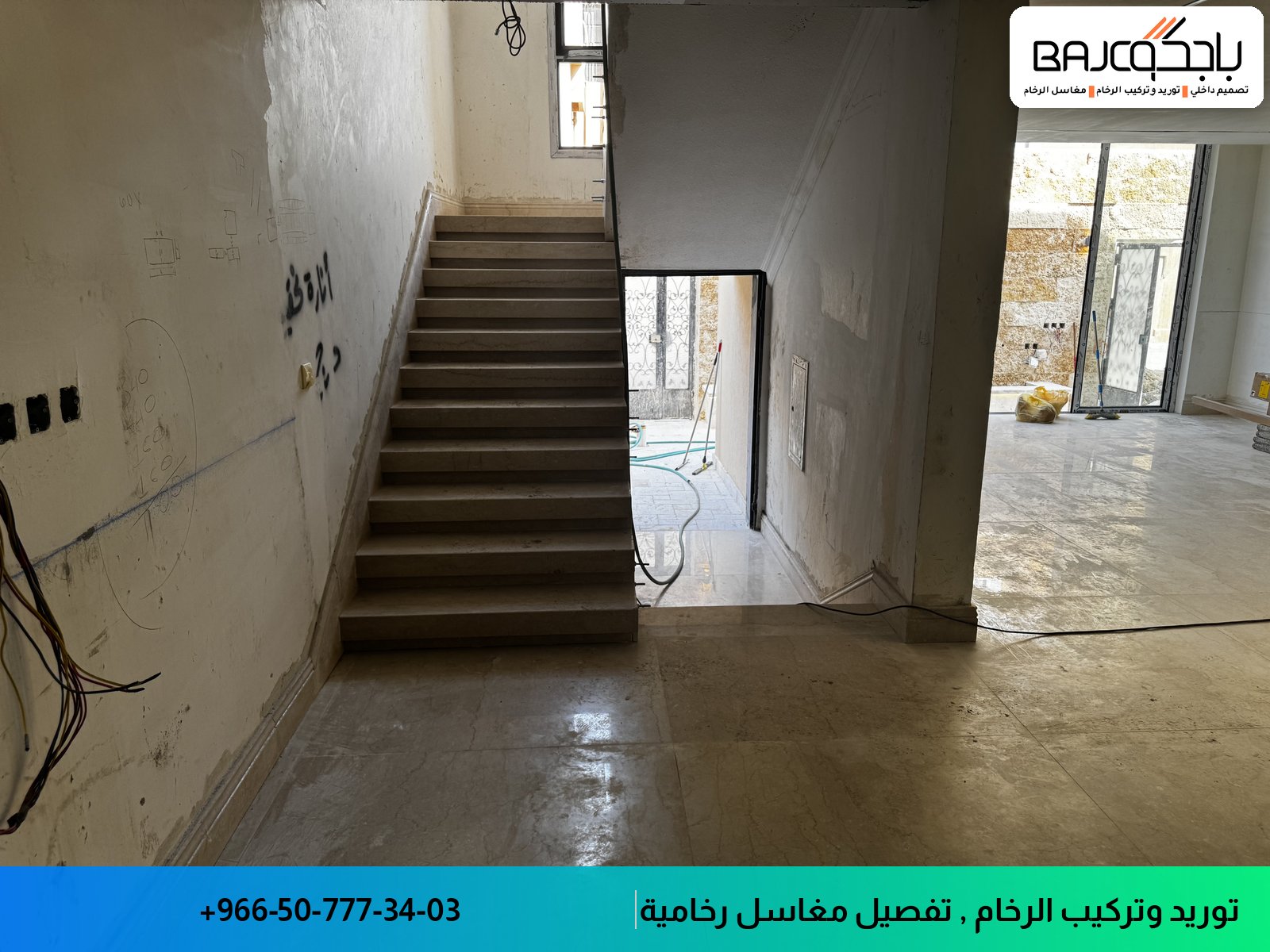 درج من الرخام البيج الفاتح مع جدران بيضاء وأرضية خرسانية في مرحلة التشطيب