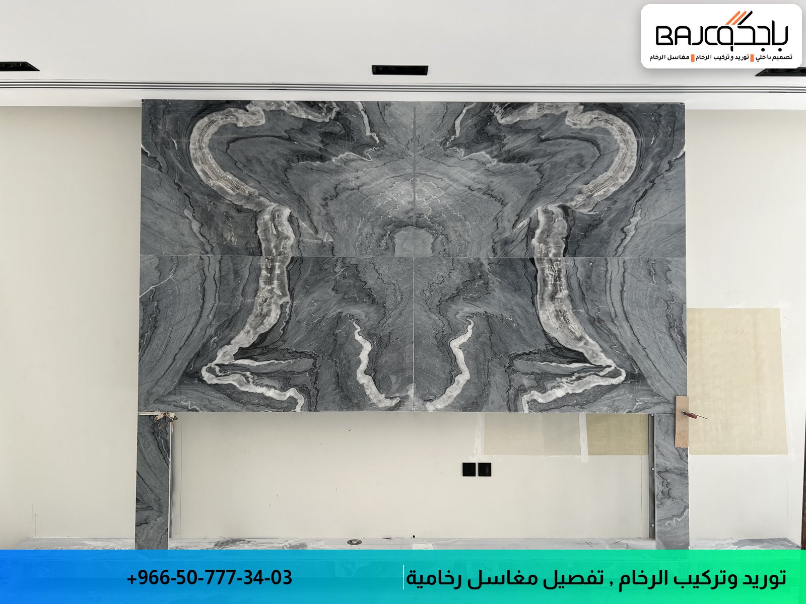 جدارية رخام سوداء رمادية بتصميم متماثل وعروق بيضاء في جدار حمام