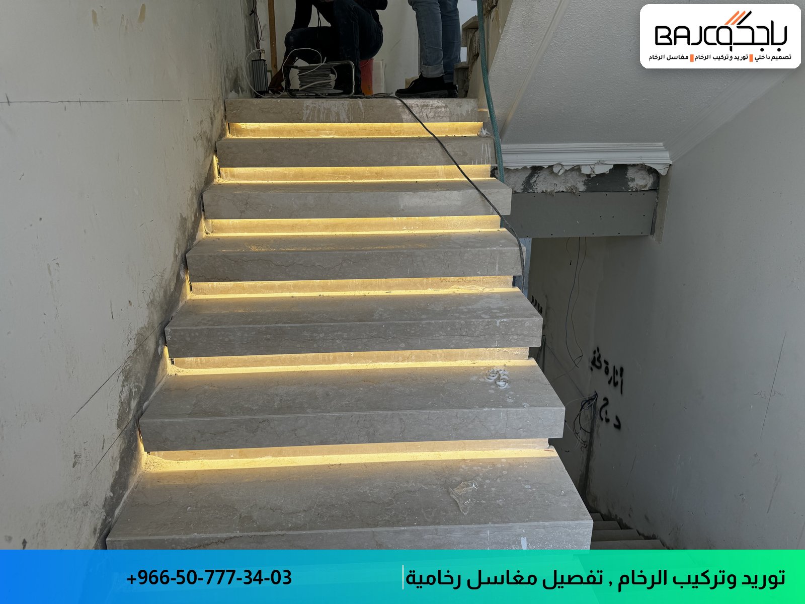 درج رخام رمادي طبيعي مع شرائط إضاءة LED ذهبية مدمجة أسفل كل درجة، موضع في مدخل عمارة