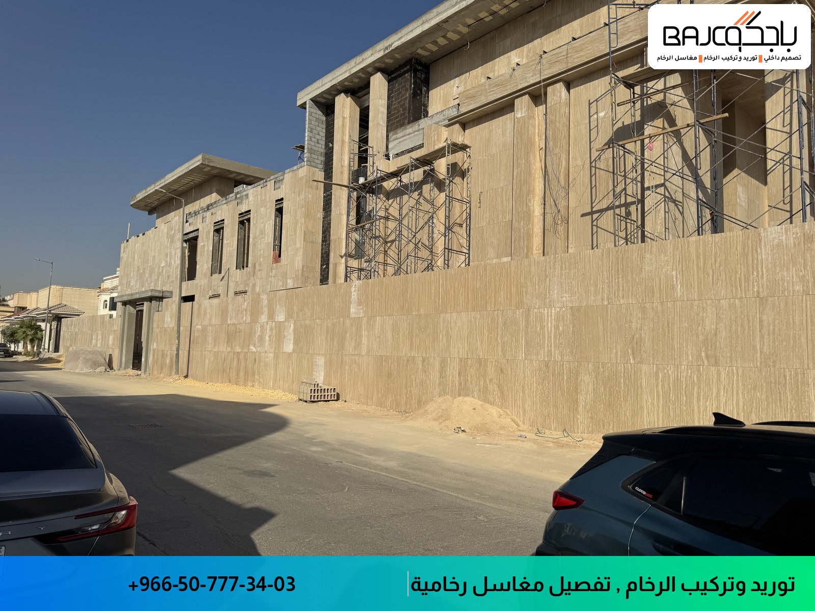 واجهة مبنى مكسوة بحجر رملي بيج فاتح مع سقالات معدنية على الجانب الأيمن