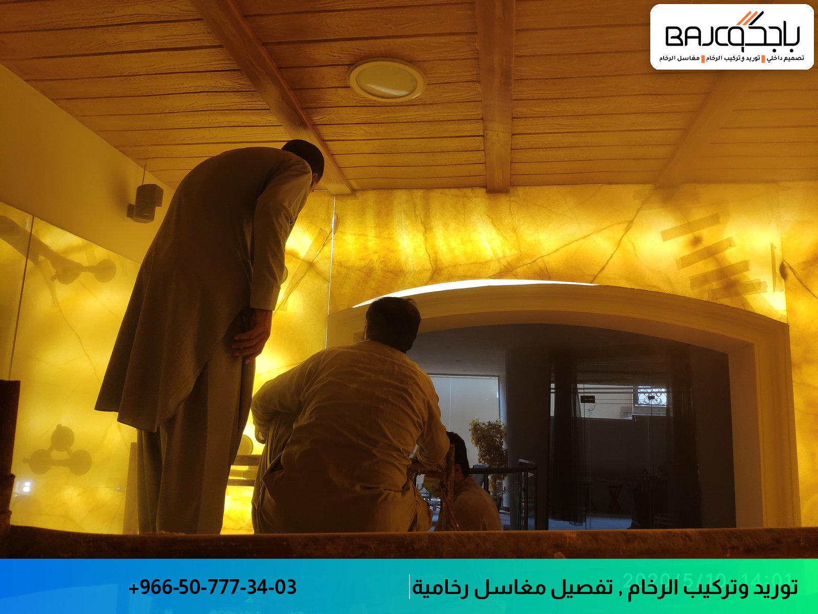 عاملان يقومان بأعمال تصميم داخلي وتفصيل في مساحة مضاءة بإضاءة دافئة مع سقف خشبي