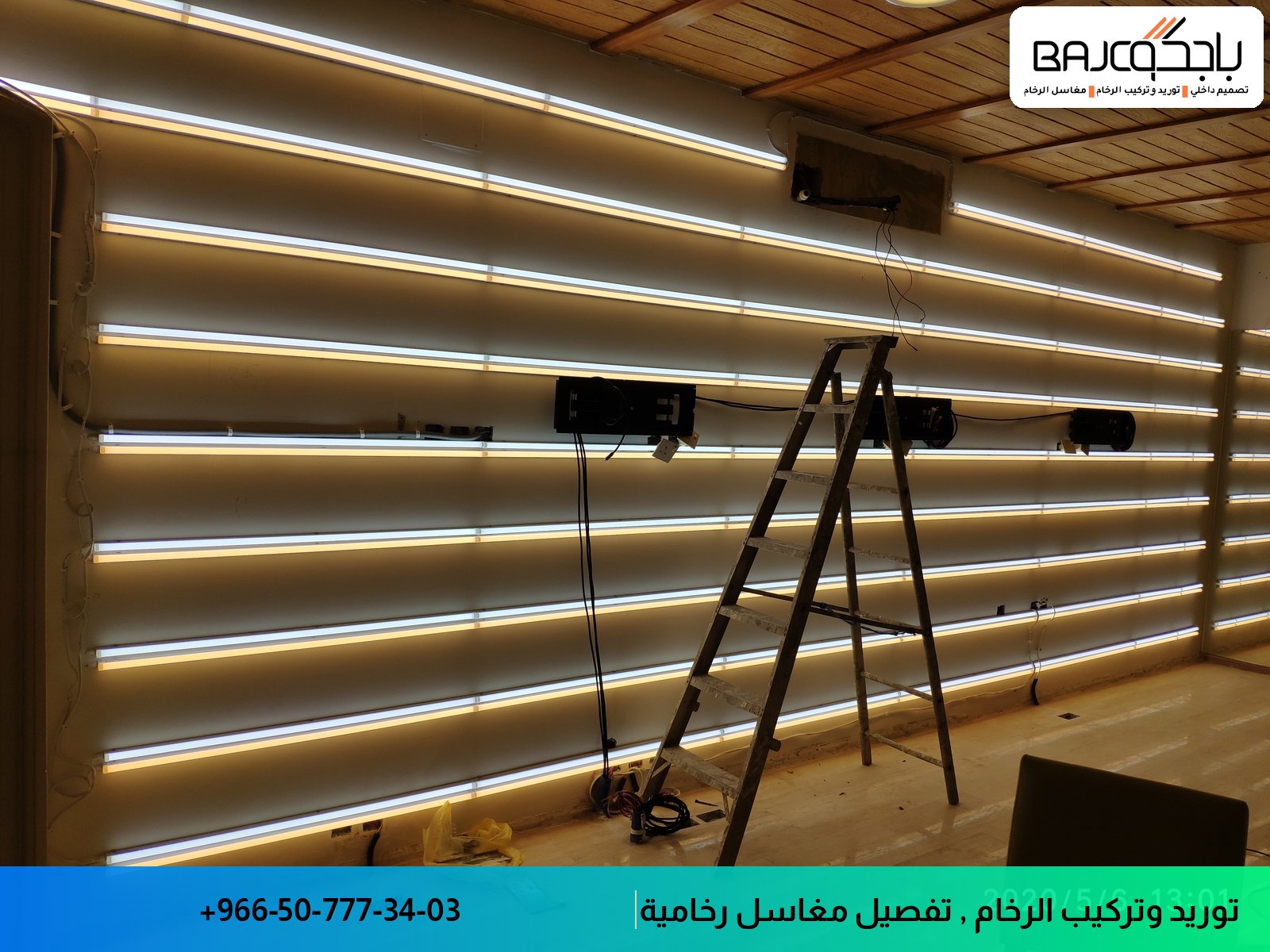 جدارية بيضاء بخطوط أفقية وإضاءة LED متكاملة، تحت سلم معدني أثناء التثبيت