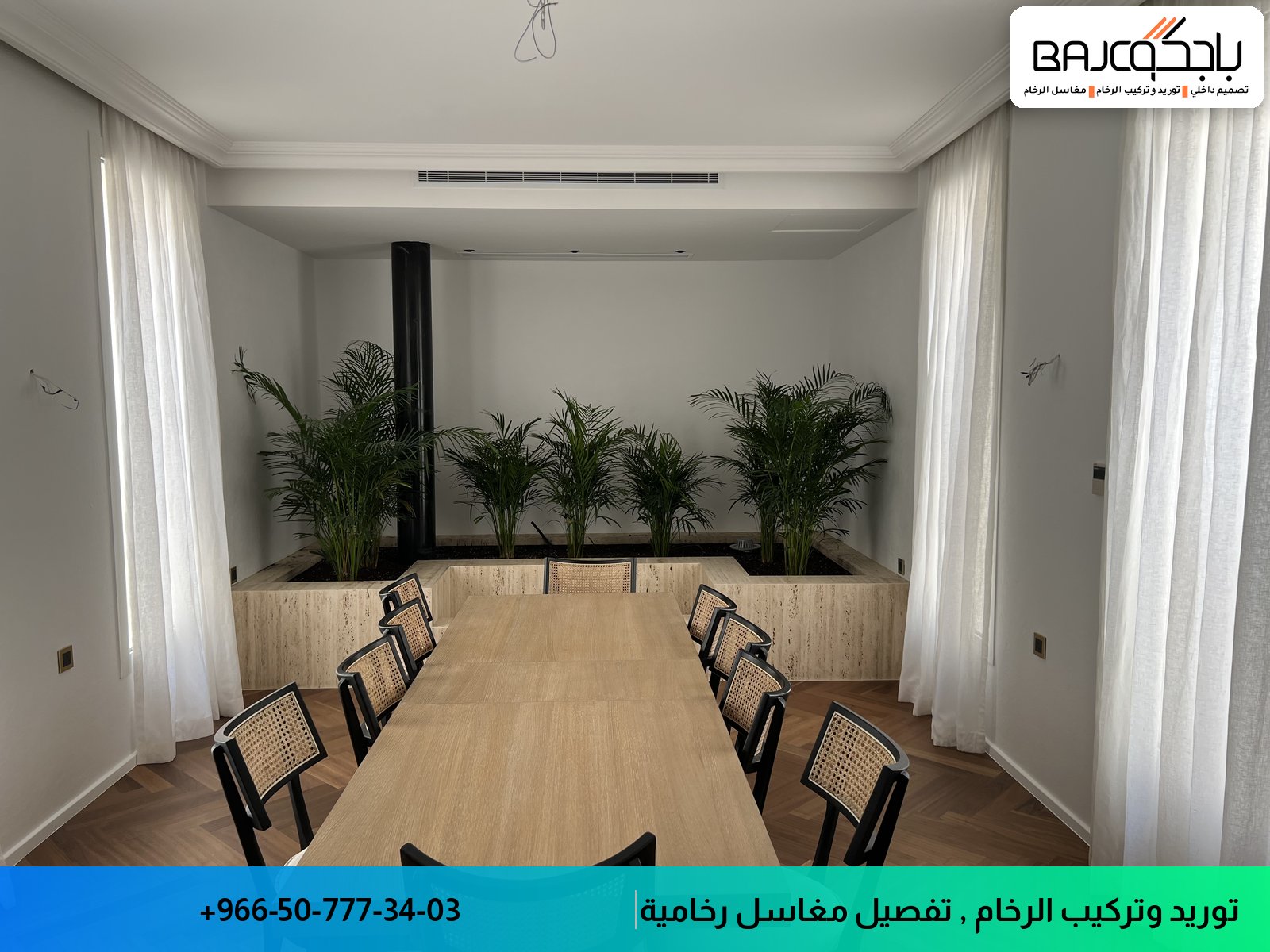 قاعة اجتماعات بطاولة خشبية طويلة وكراسي سوداء وأرضية باركيه وجدارية نباتات خلفية