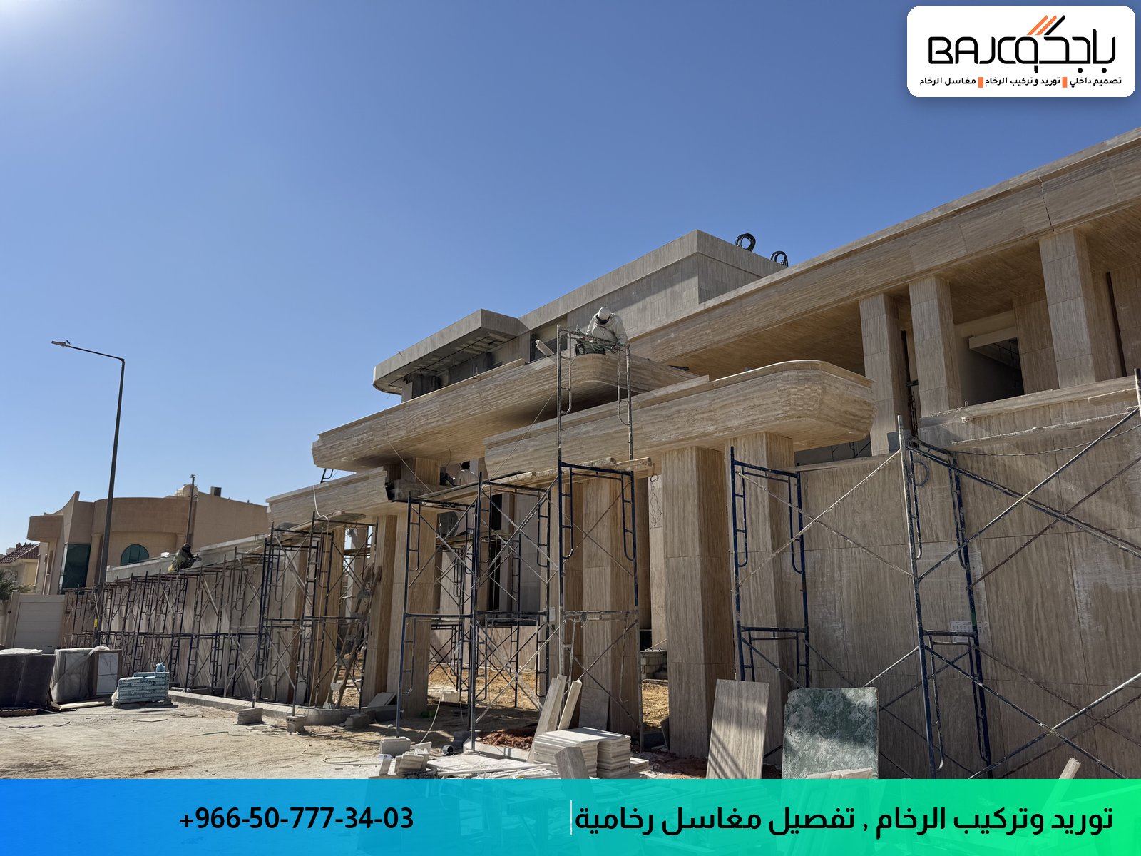 واجهة مبنى قيد التشطيب مع تركيب رخام كريمي اللون على الجدران باستخدام سقالات معدنية وأدوات تفصيل متخصصة