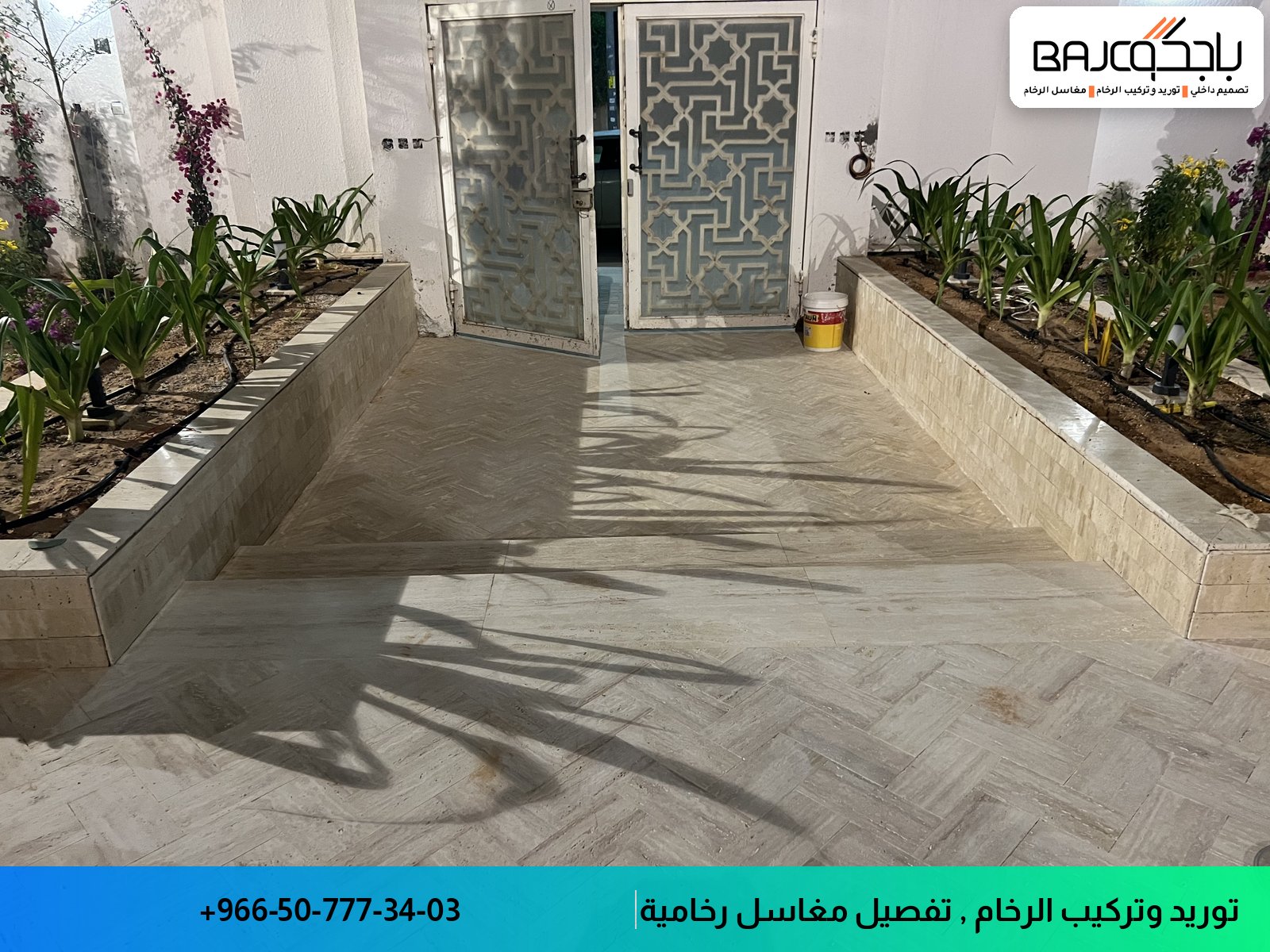 ممر بأرضية رخام أبيض بعروق رمادية منسقة هندسياً، محاط بأحواض رخام تحتوي على نباتات خضراء