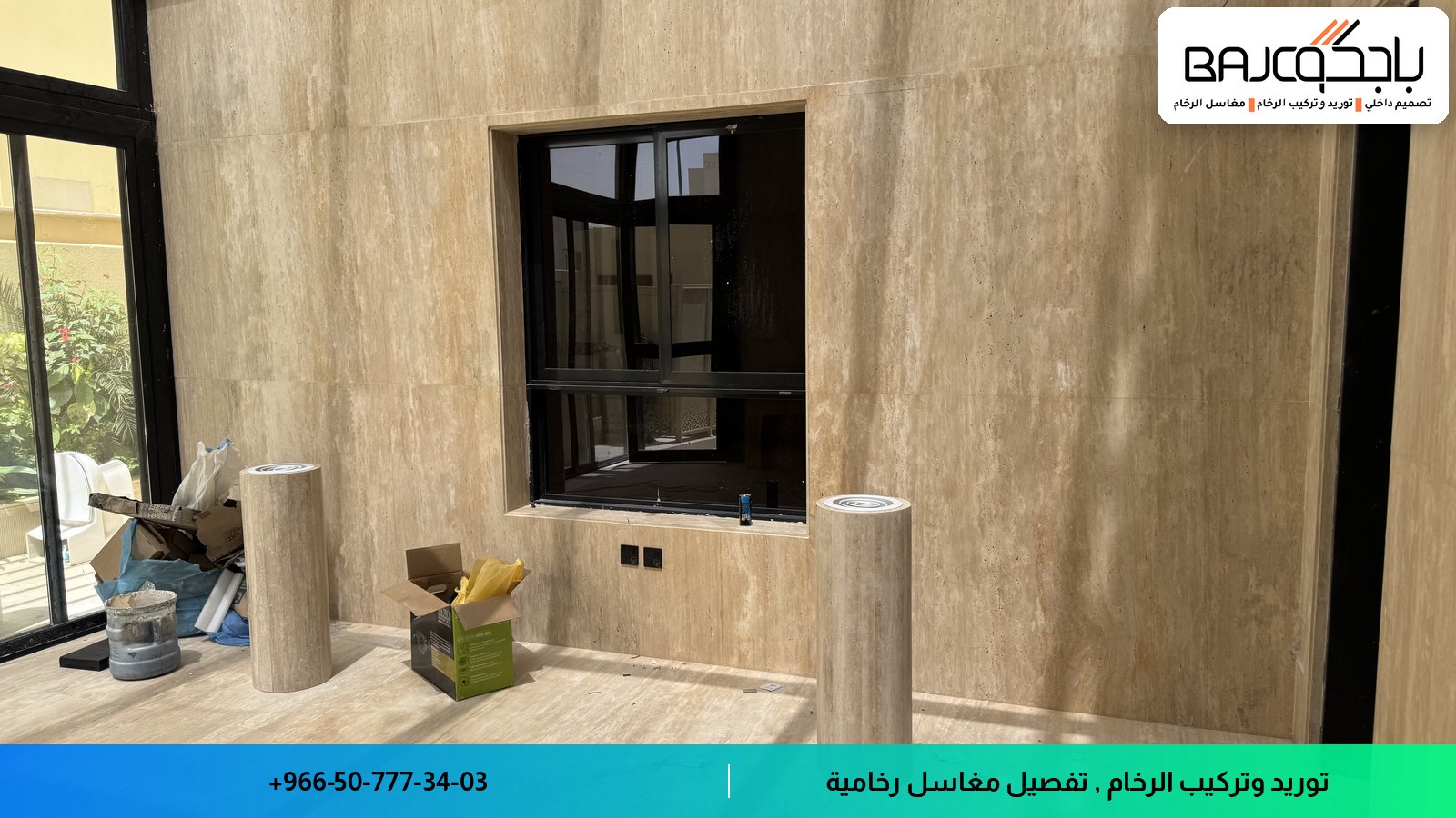 جدار مغطى برخام بيج فاتح مع نافذة سوداء وأرضية خشبية في مشروع تصميم داخلي