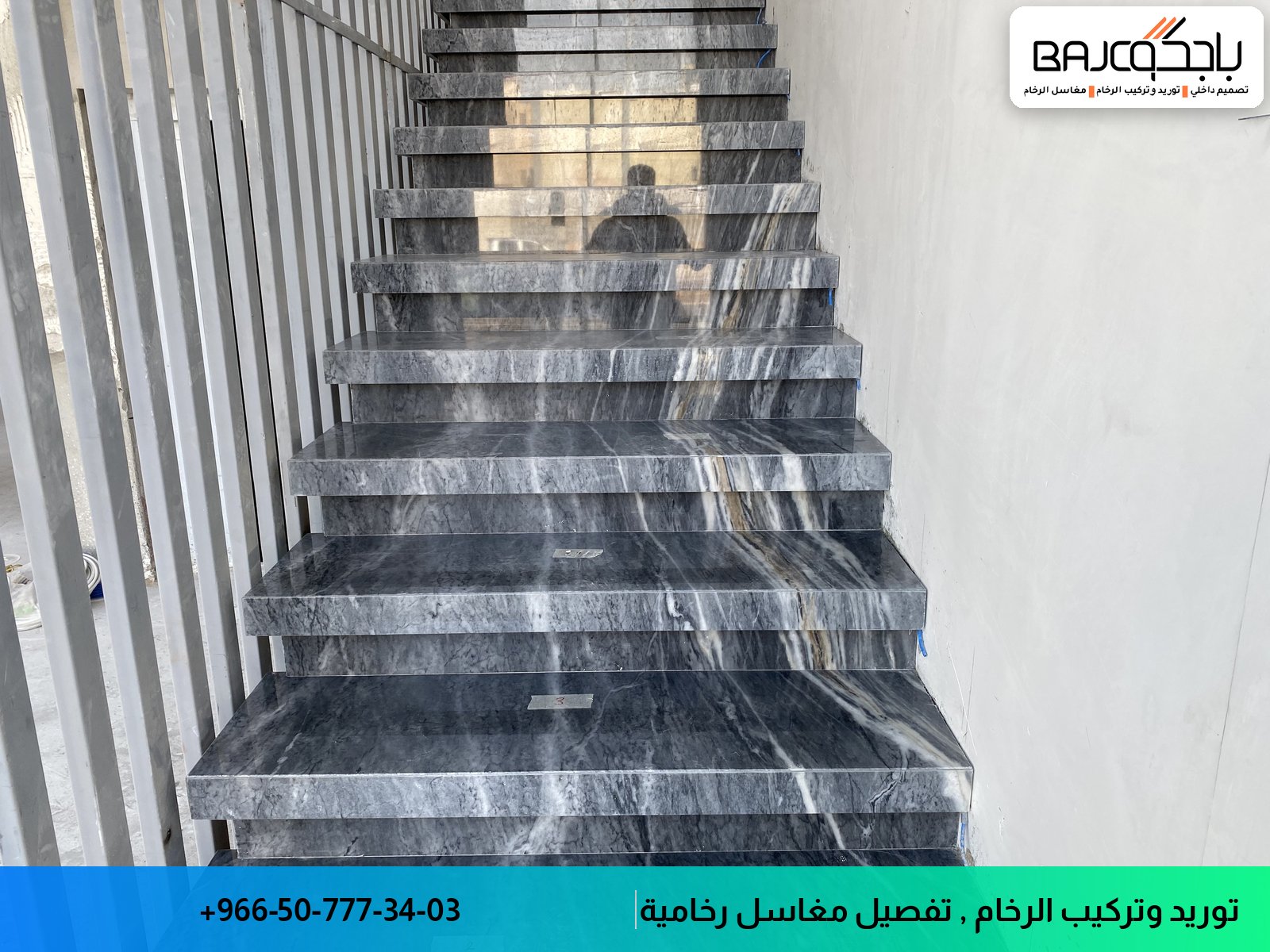 درج داخلي من الرخام الأسود مع عروق بيضاء ودرابزين معدني، إضاءة طبيعية من الأعلى