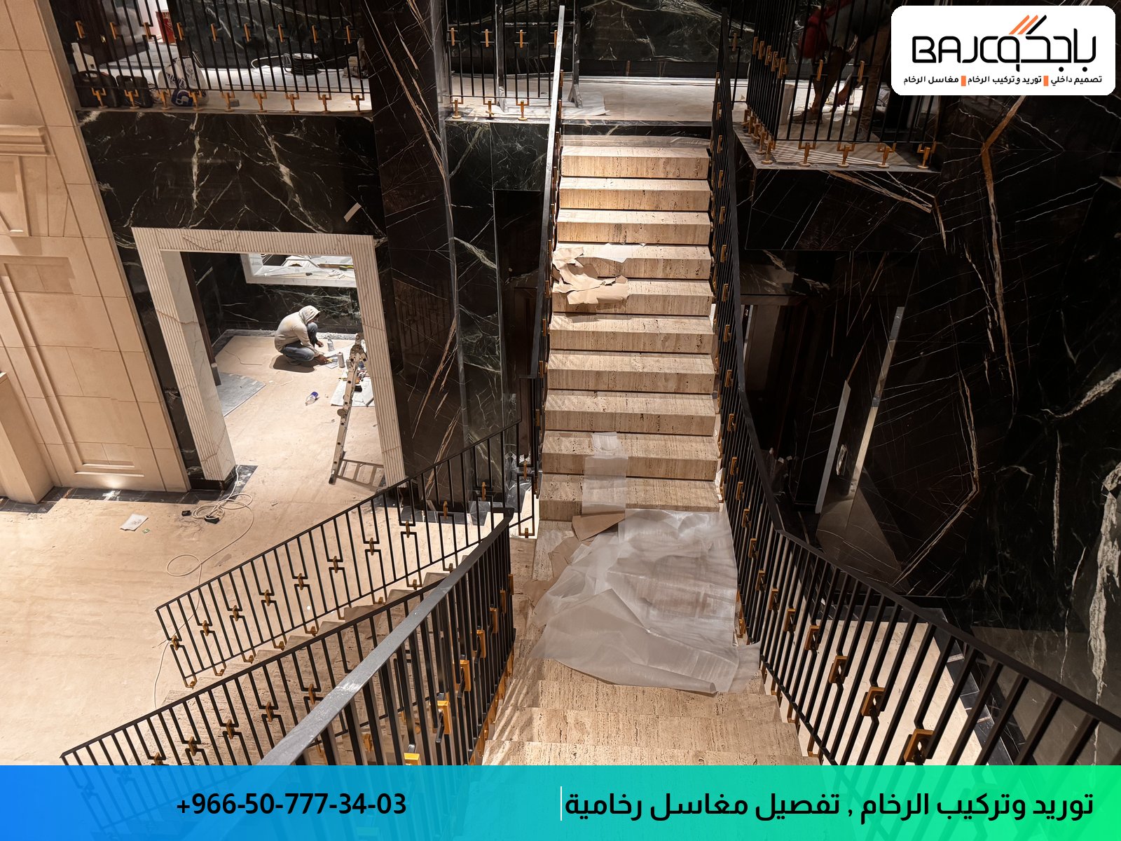 درج رخام أسود بعروق بيضاء في مبنى سكني قيد الإنشاء، مع درابزين معدني ودهانات حائطية داكنة